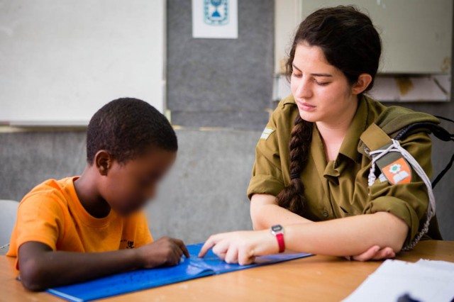 Israeli soldier helping teach student in Israel